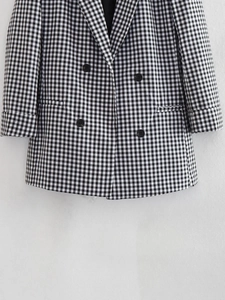 Detail of classic black and white plaid blazer with double-breasted buttons and lapel