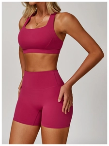 Dettaglio del reggiseno sportivo elasticizzato e pantaloncini yoga a vita alta color bacca