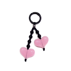 Handmade beaded keychain with pink heart pendants and black beads on white background