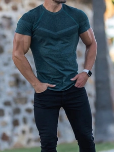 Detailed view of dark green moisture-wicking athletic tee with geometric shoulder patterns