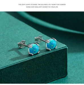 Détail de boucles d'oreilles en argent 925 avec opale bleue sur support vert