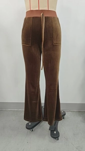 Detail of brown velvet flared pants featuring elastic waistband and matching drawstring