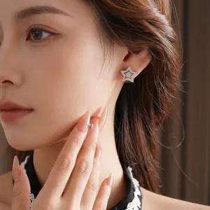 Micro-set zircon star stud earrings in silver finish worn on ear for women