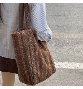 Close-up of brown wool tote bag with green stripes in a street style winter setting