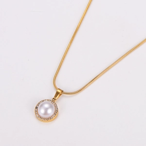 Minimalist gold necklace with round pearl pendant and pavé diamond halo on snake chain