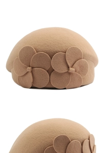 Detailed macro view of the camel wool beret with side-stitched 3D floral decorations
