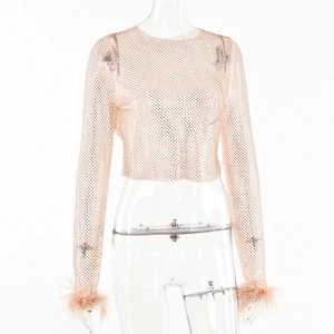 Détail du haut court en maille rose avec des finitions élégantes en plumes aux poignets