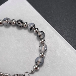 Close-up of beaded bracelet with grey agate and silver metal beads and link chain