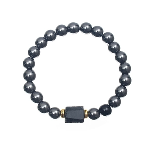 Detailed view of beaded bracelet with dark metallic spheres and a black rectangular stone