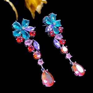 Detail of long drop earrings featuring multicolor pear-shaped gemstones and black metal base
