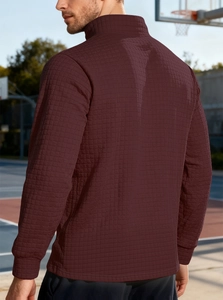 Detail of burgundy waffle knit texture on men's stand collar pullover sports sweatshirt