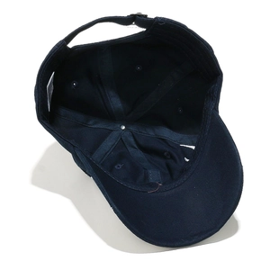 Detail view of navy blue baseball cap interior featuring six-panel twill cotton and metal buckle
