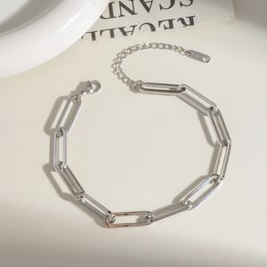 Detail view of two-tone stainless steel paperclip link bracelet in silver and rose gold
