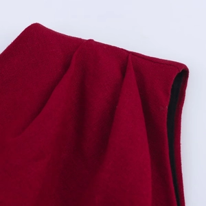 Close-up of deep red linen dress showing woven texture and pleated shoulder detail