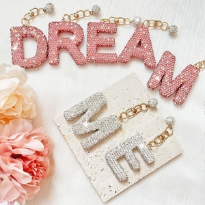 Detail of pink and silver diamond-encrusted alphabet charms for cups and bags
