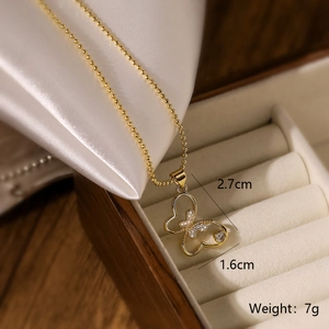 Detail of 18K gold plated butterfly pendant necklace with zircon on white silk