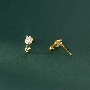 Macro shot of 925 silver tulip stud earrings with gold plating and cubic zirconia