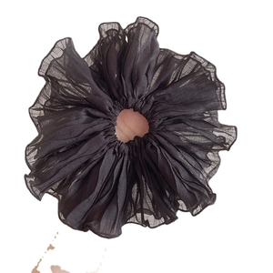 Oversized black ruffled chiffon scrunchie with elegant pleated texture on white background