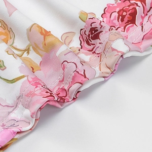 Gros plan du tissu fleuri avec roses roses et double couture détaillée sur l'ourlet