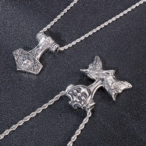 Macro detail of silver Thor's hammer pendant with intricate wolf head engraving