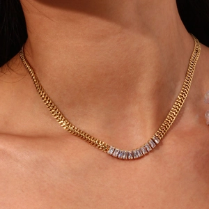 Gros plan sur un collier doré en V serti de zircons avec une chaîne en épi