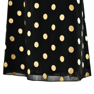 Dettaglio ravvicinato di tessuto in chiffon nero con eleganti pois dorati metallizzati