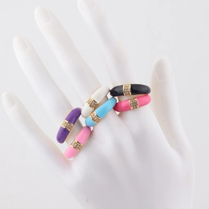 Macro detail of colorful enamel rings with gold plating and sparkling zircon inlay