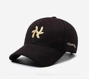 Detail of black baseball cap with gold embroidery and Nostalgia side lettering