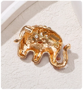 Detailed back view of the golden elephant brooch showing the secure metal safety pin clasp