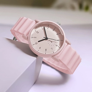Pink quartz watch with wavy silicone strap on soft geometric display stand