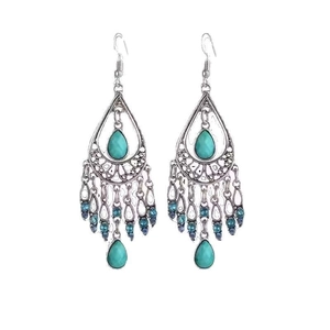 Bohemian silver drop earrings with turquoise stones and blue beaded tassels on white background