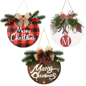 Three festive wooden Christmas door signs with bows, pine needles, and LED lights