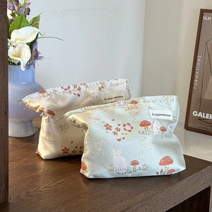 Vintage Chinese style embroidery clutch bag with floral rabbit patterns on wooden desk