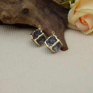 Detailed view of vintage square resin charms with gold frame and dark translucent stones