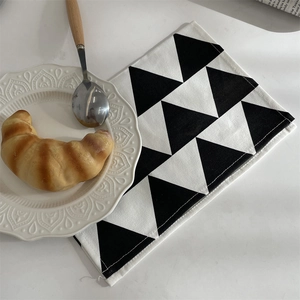 Detail of minimalist geometric napkin with black triangle patterns for dining table decor