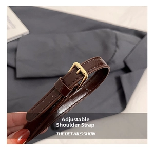 Vue détaillée de la bandoulière réglable en cuir marron avec boucle en métal doré