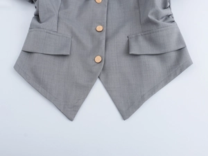 Détail du gilet gris avec trois boutons dorés et deux poches à rabat élégantes