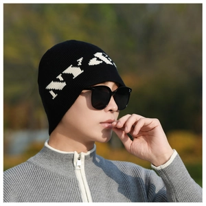 Close-up of black knitted beanie with white NY letter jacquard and stylish sunglasses