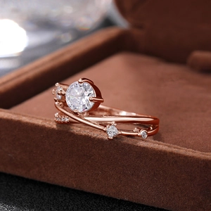 Macro-opname van rosé gouden ring met centrale diamant op bruin fluweel doosje