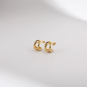 Detailed view of triple-layered gold geometric C-shaped earrings with a mirrored finish