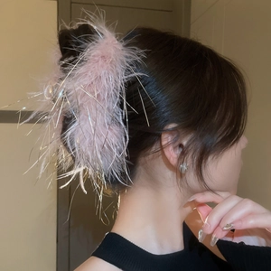 Detail of pink feather hair claw clip with silver tinsel for elegant hairstyles