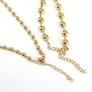 Detail of gold bead necklace with adjustable lobster clasp and extension chain