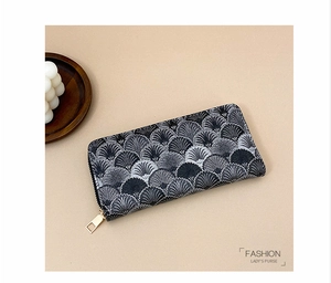 Detail view of women's long wallet with fan-patterned embroidery and gold zipper
