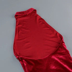 Detail of red velvet backless dress showing halter neck button and elegant fabric sheen