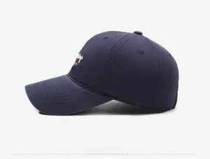 Close-up of navy blue cotton baseball cap with detailed side embroidery on twill fabric