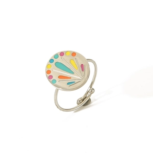 Close-up of bohemian silver adjustable ring with colorful enamel patterns on white background