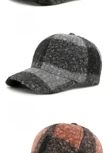 Dettaglio di cappellini da baseball in bouclé a quadri per l'inverno, grigio e arancione
