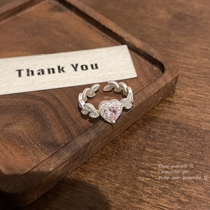 Detailed close-up of pink heart-shaped gemstone ring with crystal leaf accents
