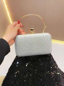 Detail of silver glitter evening clutch with elegant gold metal handle for formal events