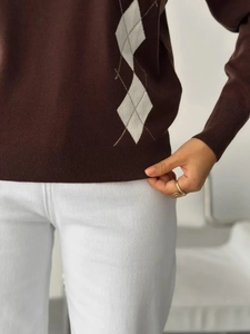 Detailed close-up of dark brown knit sweater hem with argyle pattern and ribbed texture
